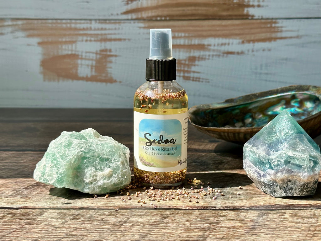 Bottle of Sedna Goddess Ritual oil product with crystals on a wooden surface