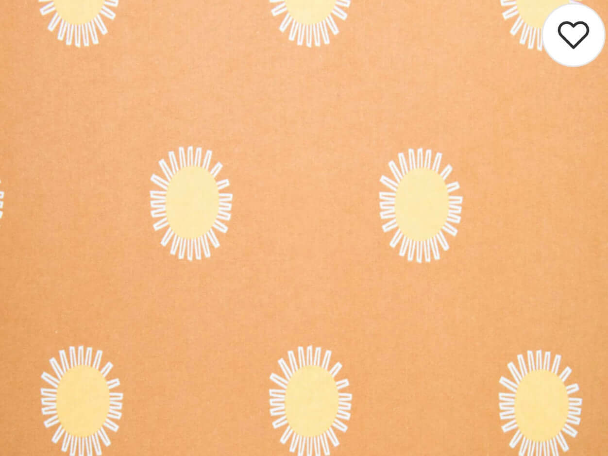 Rice heating pad made with soft cotton flannel with suns printed all over it - orange background