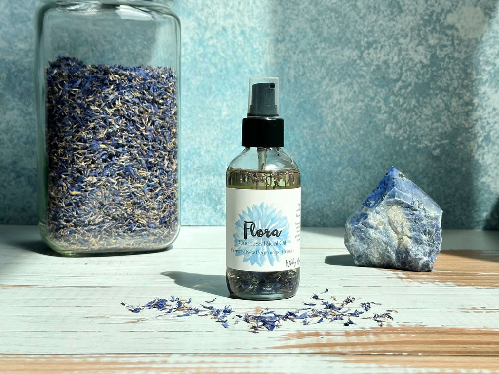Bottle of Flora product with dried flowers and a crystal on a wooden surface
