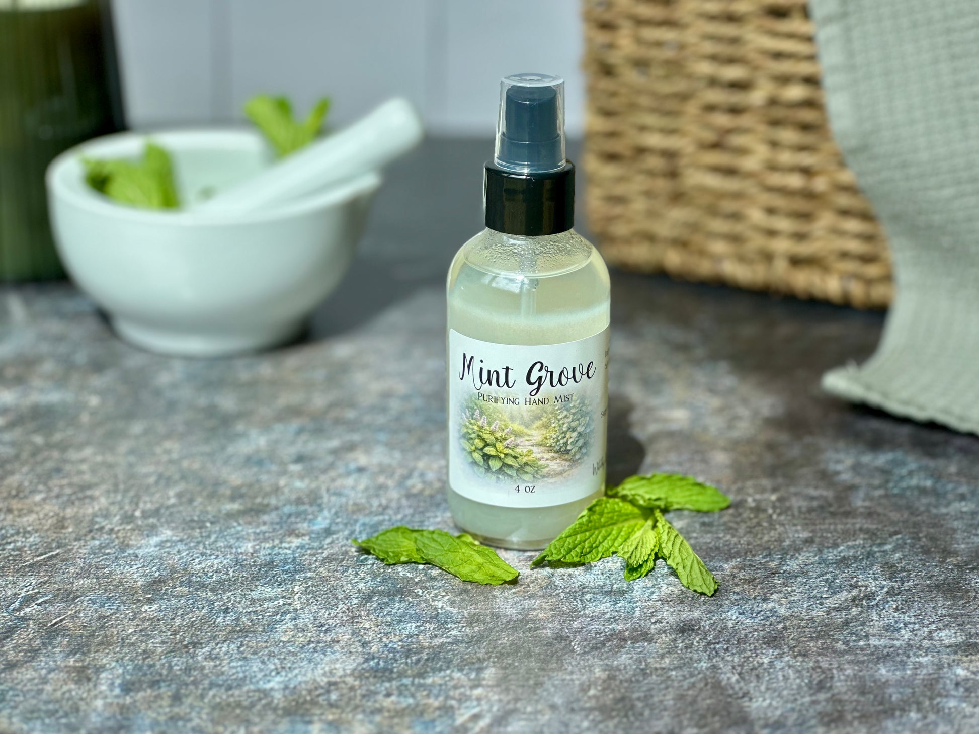 Mint Grove Purifying Hand Mist bottle with fresh mint leaves and a bowl in the background.