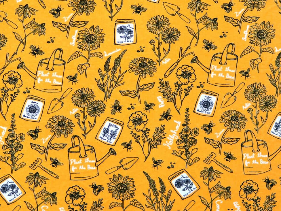 Rice heating pad made with soft cotton flannel with flowers, seed packets, and watering cans printed all over it - mustard yellow background