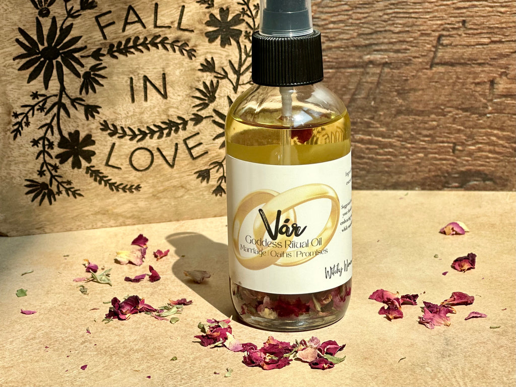Bottle of Vár Goddess Facial Oil with dried flowers on a wooden surface