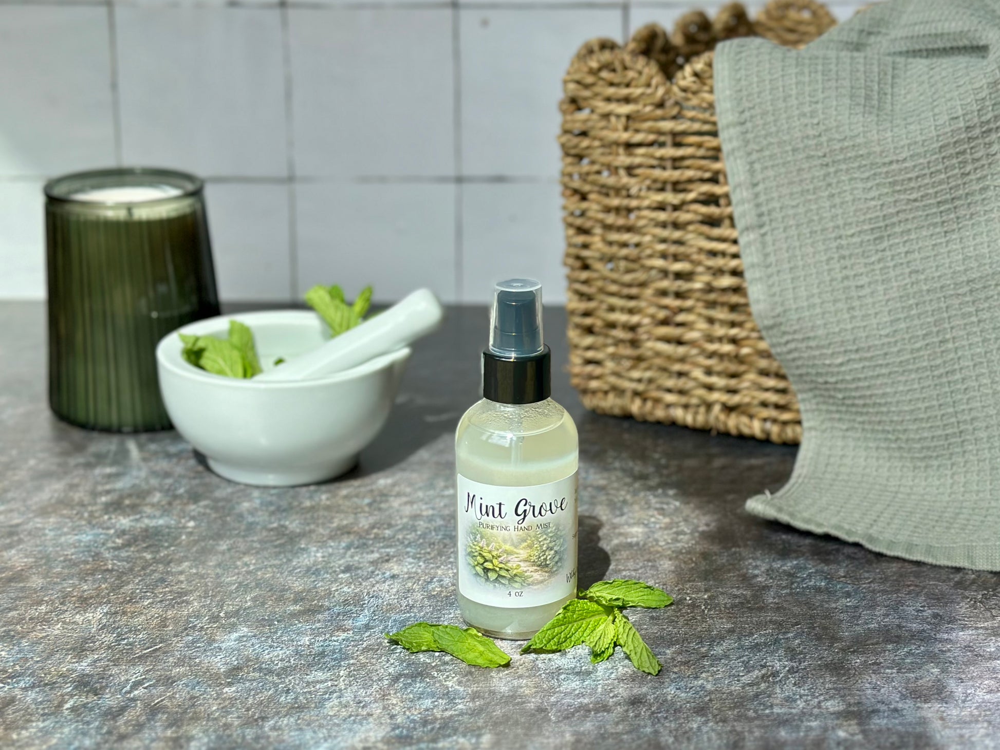 Mint Grove Purifying Hand Mist bottle with fresh mint leaves and a bowl in the background.
