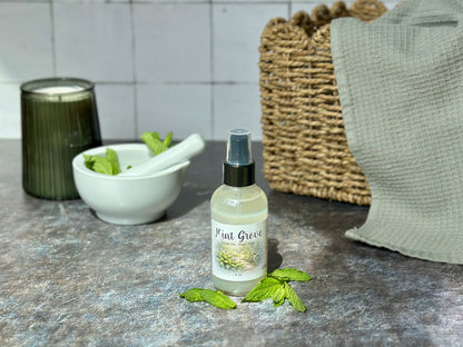 Mint Grove Purifying Hand Mist bottle with fresh mint leaves and a bowl in the background.