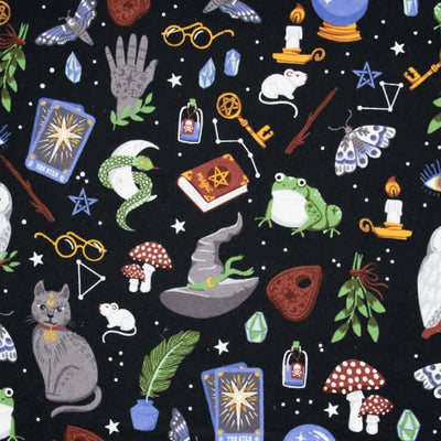 Rice heating pad made with soft cotton flannel with owls, toads, mushrooms and other magical objects printed all over it- black background