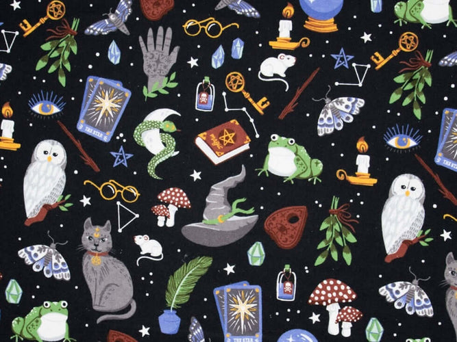 Rice heating pad made with soft cotton flannel with owls, toads, mushrooms and other magical objects printed all over it- black background