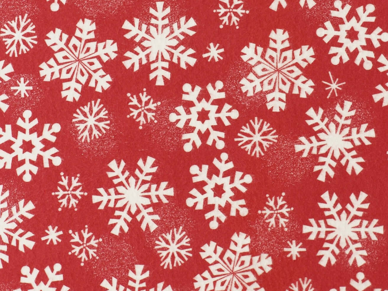 Rice heating pad made with soft cotton flannel with snowflakes printed all over it - red background