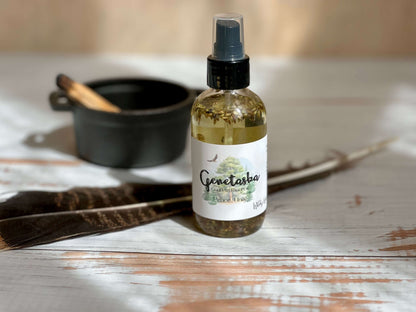 Genetaska Goddess Ritual Oil bottle with feathers and bowl in serene setting, promoting tranquility and inner peace.