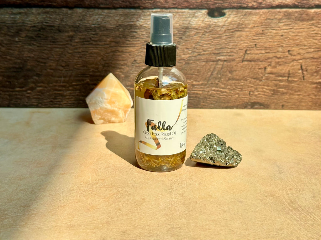 Fulla Goddess Ritual oil spray bottle with a label on a wooden surface with stones.