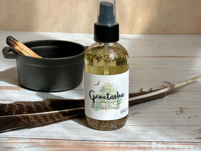 Genetaska Goddess Ritual Oil bottle placed beside a black bowl and feathers, promoting peace and tranquility.