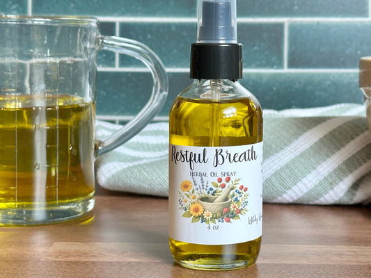 Bottle of 'Restful Breath' herbal oil spray next to a glass mug on a wooden surface.