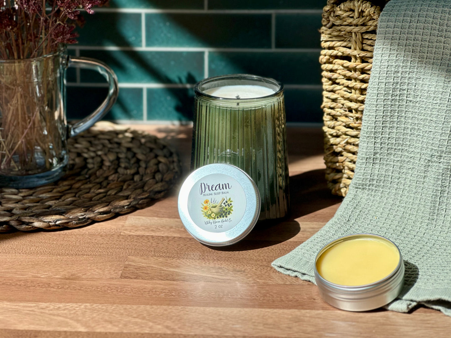 Dream Healing Sleep Balm beside a calming candle and dried flowers on a wooden table, perfect for bedtime rituals.