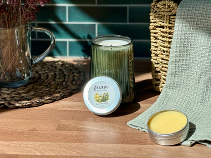 Dream Healing Sleep Balm beside a calming candle and dried flowers on a wooden table, perfect for bedtime rituals.