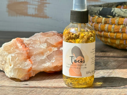 Bottle of Toci Goddess Ritual oil with a crystal and woven basket in the background