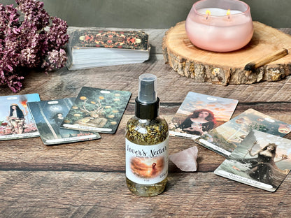 Lover's Nectar Ritual Oil Spray bottle displaying organic oils surrounded by candles and crystals.