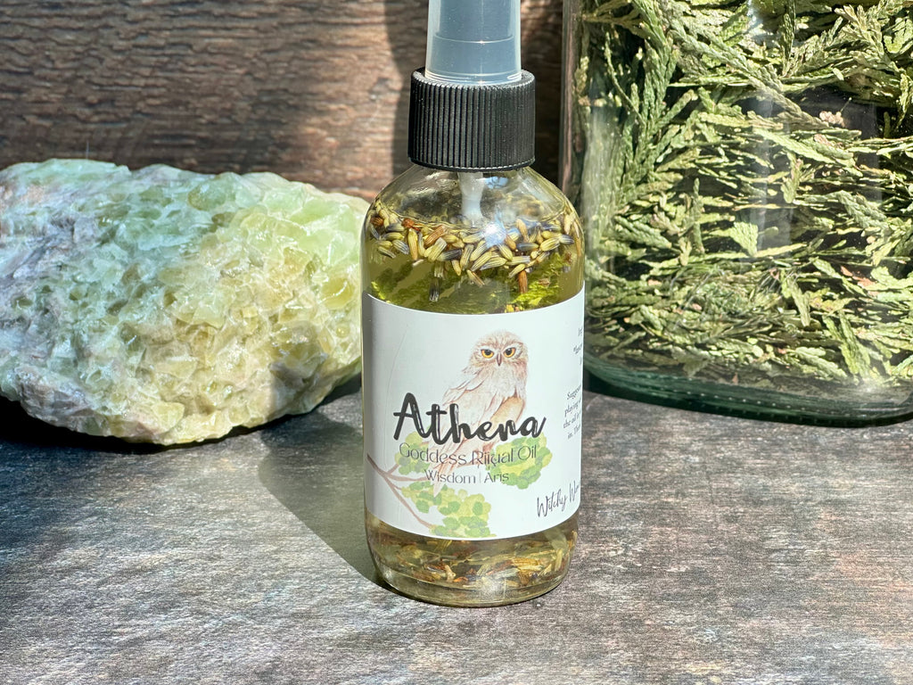 Bottle of Athena product with a label featuring an owl, on a wooden surface with greenery.