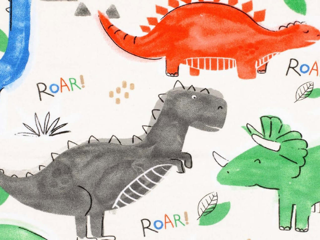 Rice heating pad made with soft cotton flannel with green, red, black, and blue dinosaurs printed on it