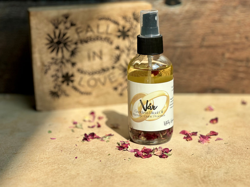 Var bottle with a label on a textured surface with flowers and a cardboard box in the background.