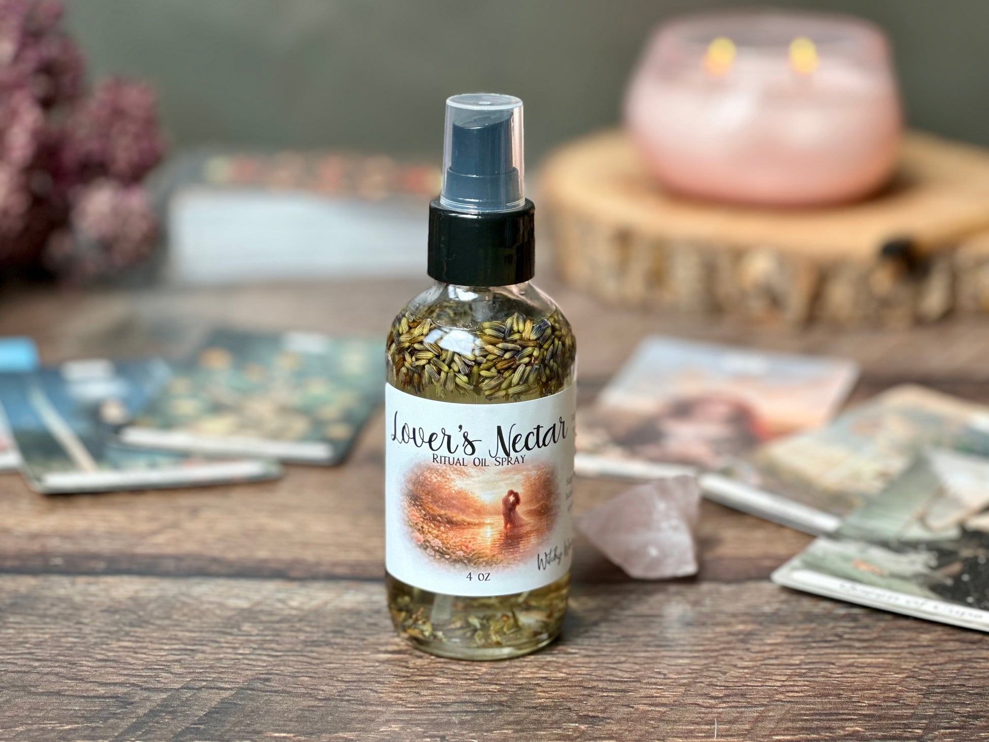 Lover's Nectar Ritual Oil Spray bottle displaying organic oils surrounded by candles and crystals.