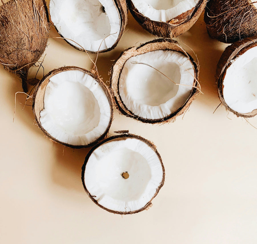 Coconuts and coconut halves on a beige background